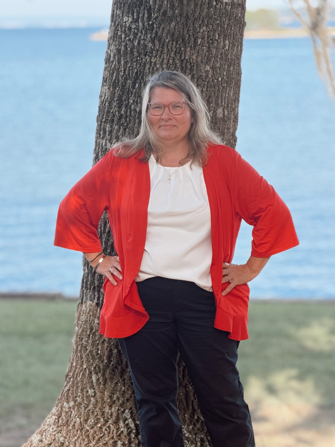 Margie West beside a tree overlooking Lake Livingston